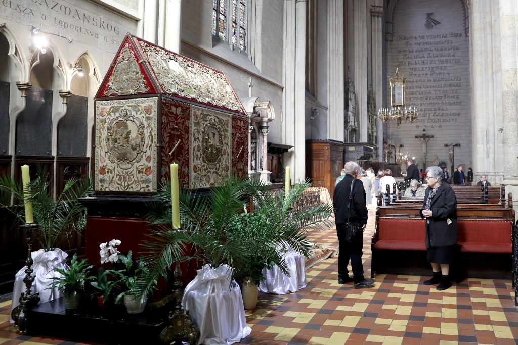 19.04.2019., Zagreb - Vjernici se od jutra u mole kod Bozjeg groba koji se tradiconolano postavlja za Vazmeno trodnevlje u zagrebackoj katedrali.  Ovaj sakralni predmet, ali i  izuzetna umjetnina ubraja se u neprocjenjivo blago riznice Katedrale.  Vezeni pokrov za Bozji grob (datira se u 1659. godinu) izradjen u tehnici reljefnog zlatoveza, remek-djelo je europske barokne umjetnosti i umjetnickog obrta tkanja. Napravljen je u Zagrebackoj biskupskoj radionici u Kasini. Autor mu je njemacki tkalac iz Ingolstadta Wolfgang Jacob Stoll, a narucitelj  je biskup Petar Petreti (1604 -1667.).
Photo: Patrik Macek/PIXSELL