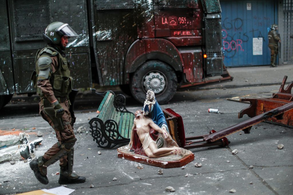 Protest against Chile's government in Santiago A member of the security forces walks past a broken religious object during a protest against Chile's government in Santiago, Chile November 8, 2019. REUTERS/Jorge Silva JORGE SILVA
